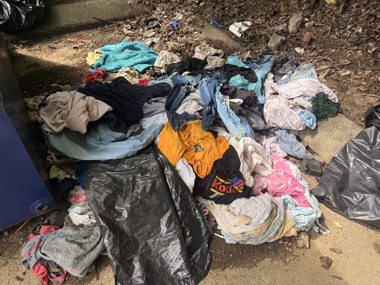 Before: pile of dumped clothing and household goods on the ground
