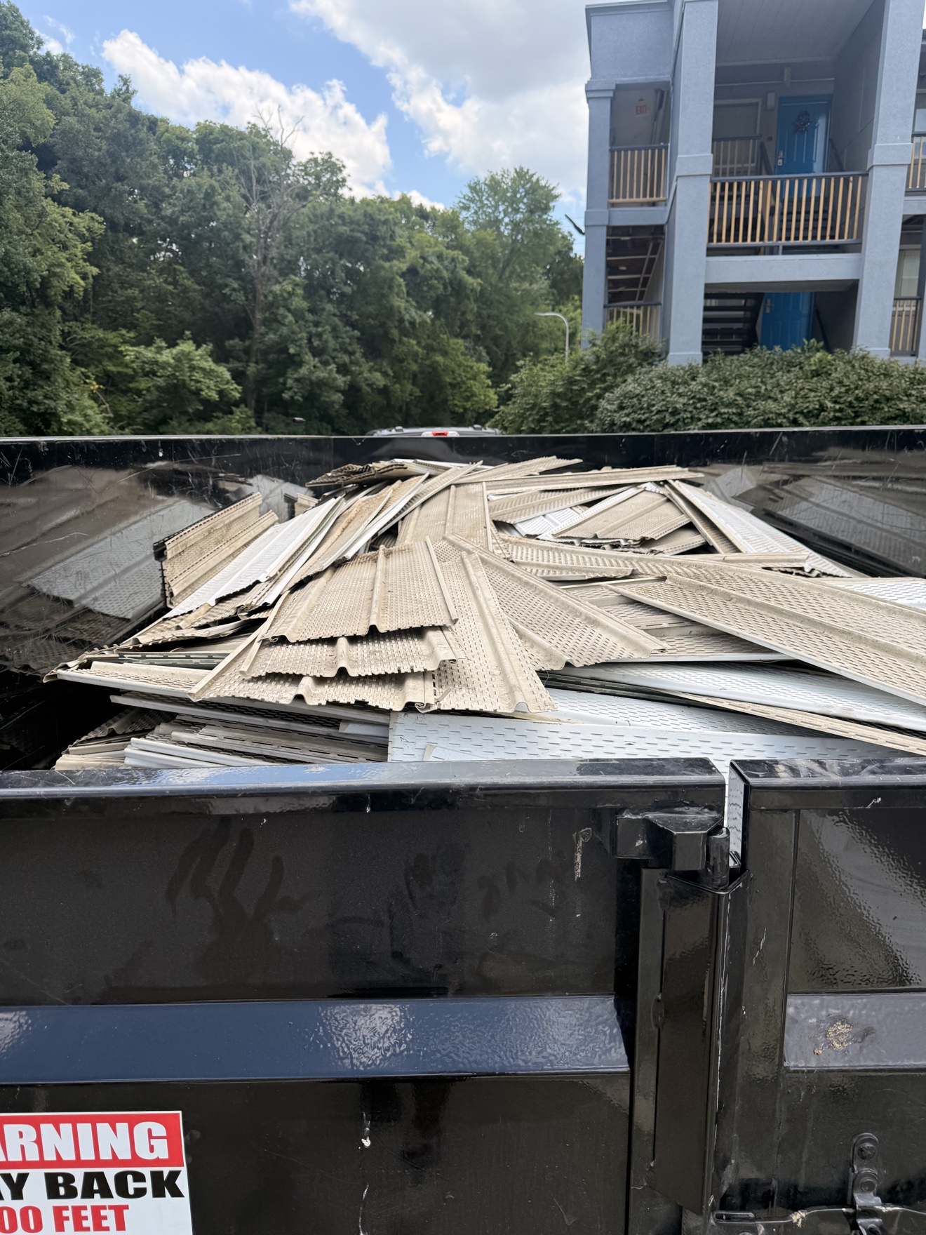 After: vinyl siding panels loaded into the Affordable Junk Removal dump trailer